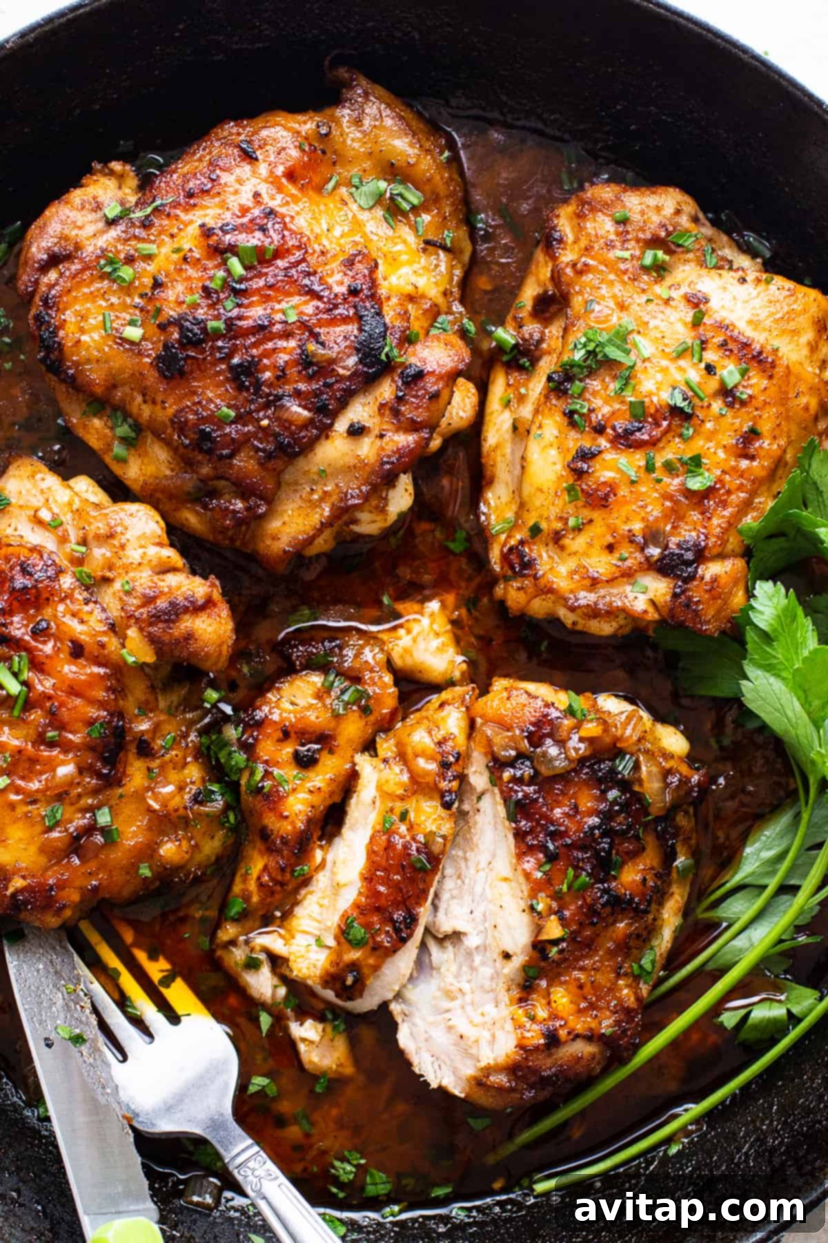 Perfectly Seared Cast Iron Chicken Thighs 8 Freshly cooked cast iron chicken thighs in a skillet with sauce, ready for serving or storage.