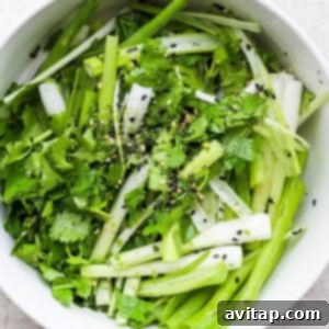 a bowl of greens with sesame seeds and sesame seeds.