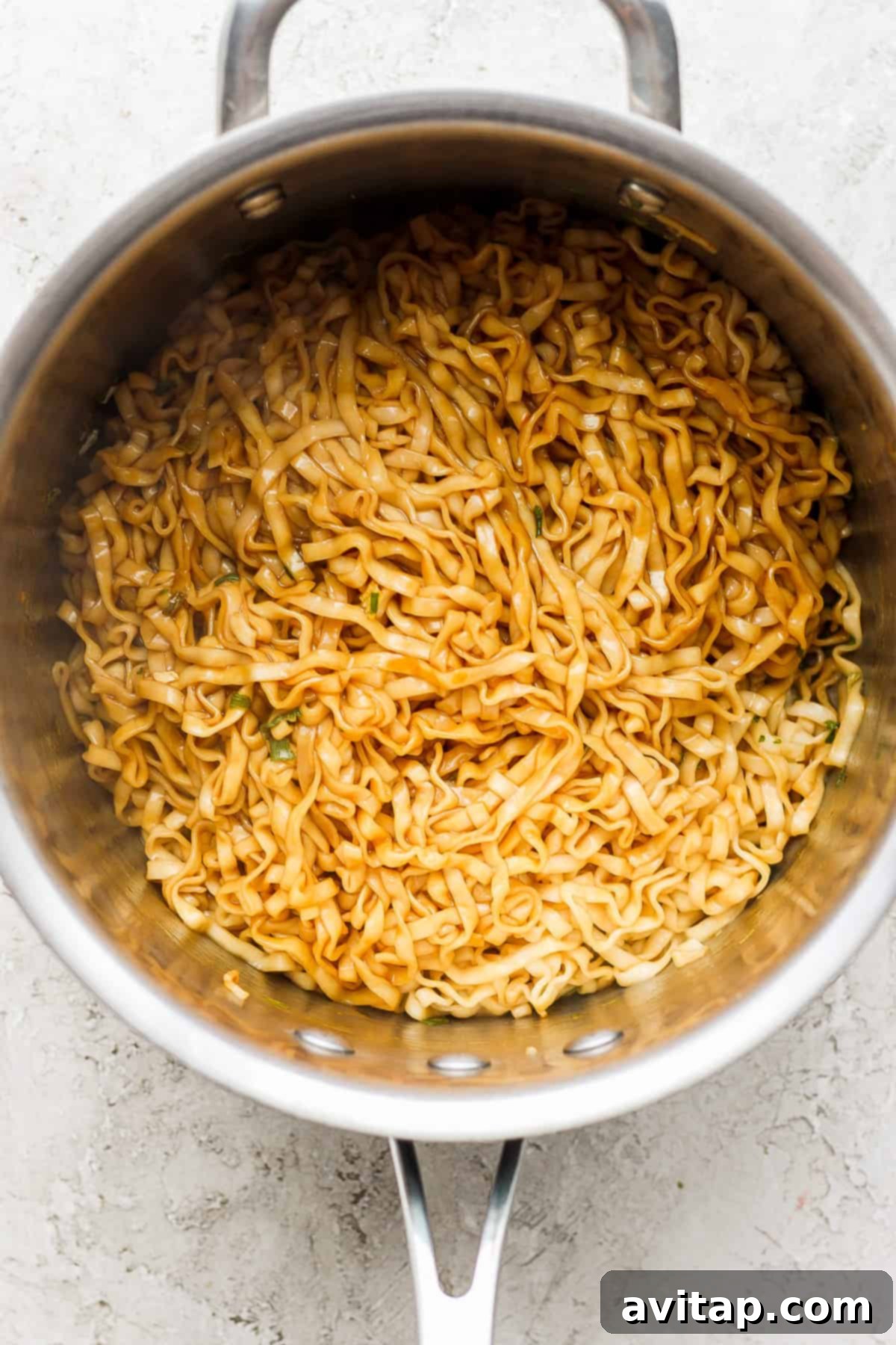 a pan with noodles in it on a white surface.