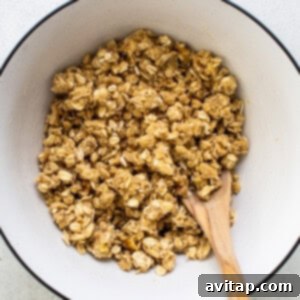 Close-up of streusel ingredients in a bowl, showing oats, nuts, and butter being crumbled together.