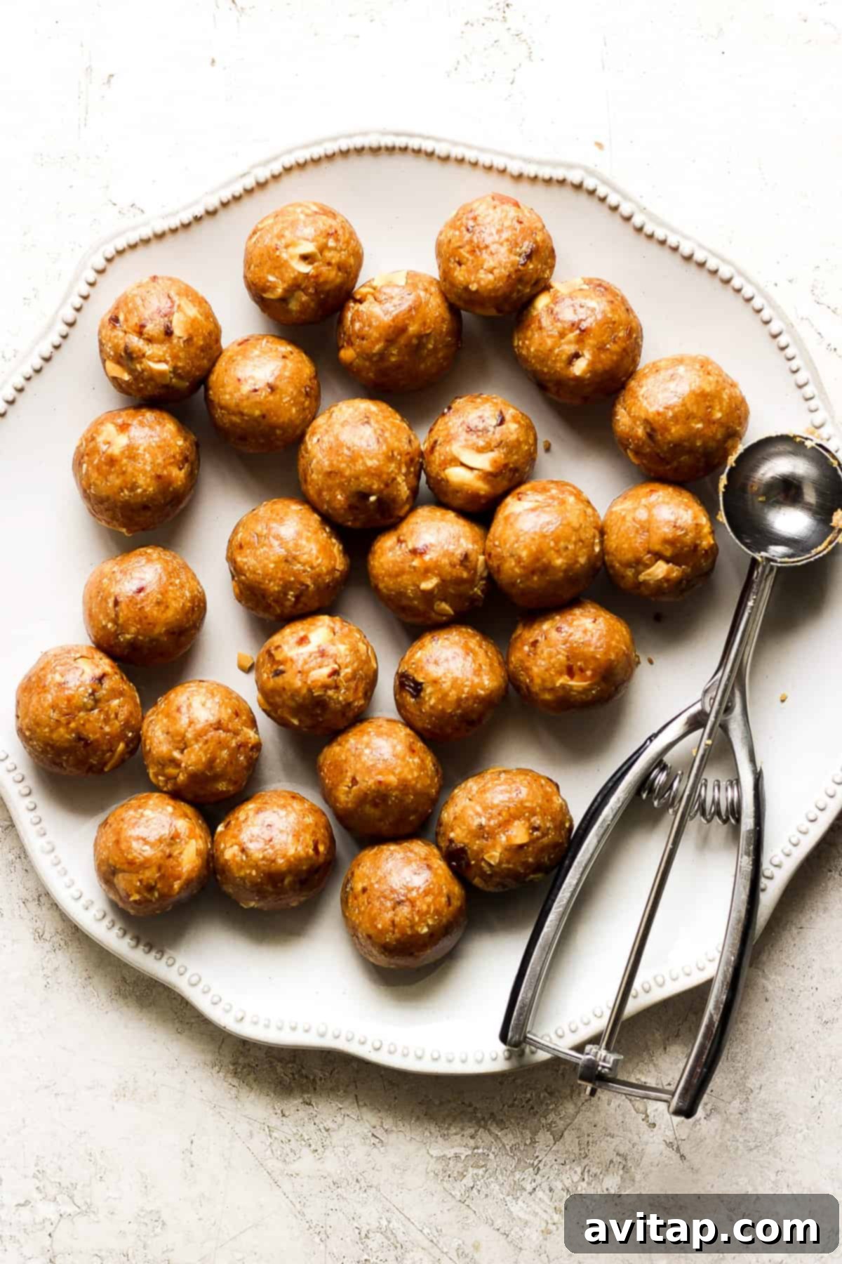 Delicious peanut butter energy balls on a plate, ready to be served, with a spatula in the background.
