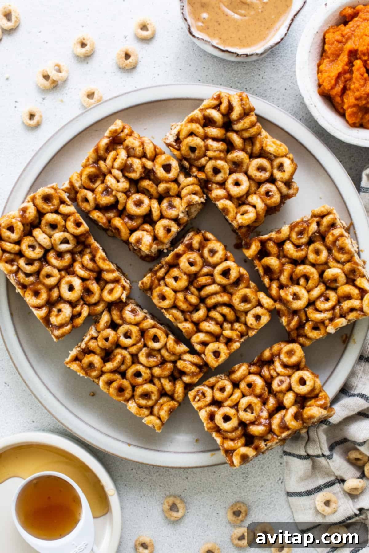 Pumpkin Spice Peanut Butter Crunch Bars 2 A plate with a plate of cereal bars and a bowl of peanut butter.