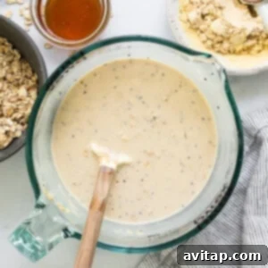 Two bowls, one filled with dry oatmeal ingredients and another with mixed overnight oats, demonstrating the initial preparation step.