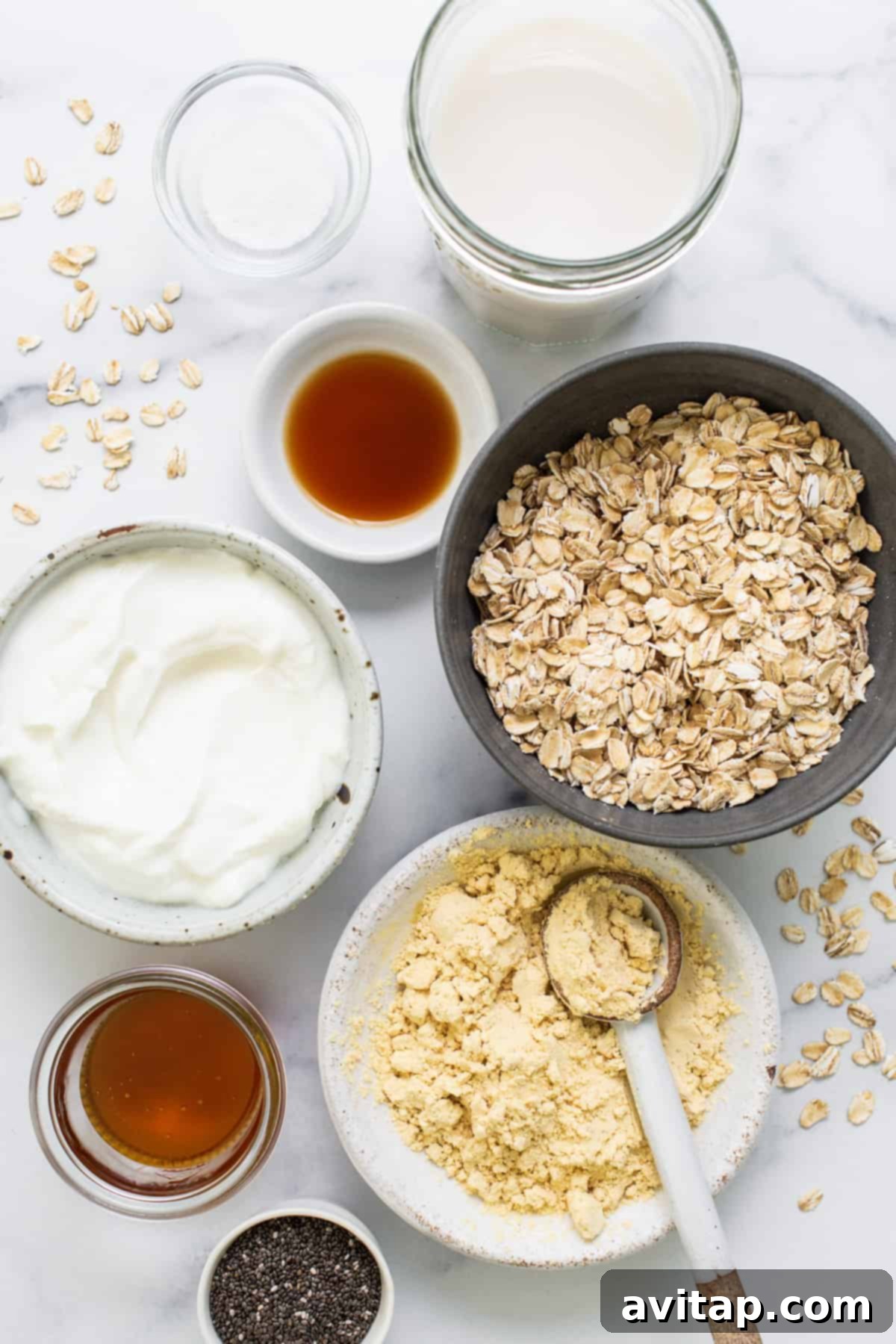 Protein Overnight Oats Three Delicious Varieties 3 A beautifully arranged table featuring several glass jars filled with colorful overnight oats, alongside fresh fruit and nuts, highlighting the variety and appeal of the recipe.