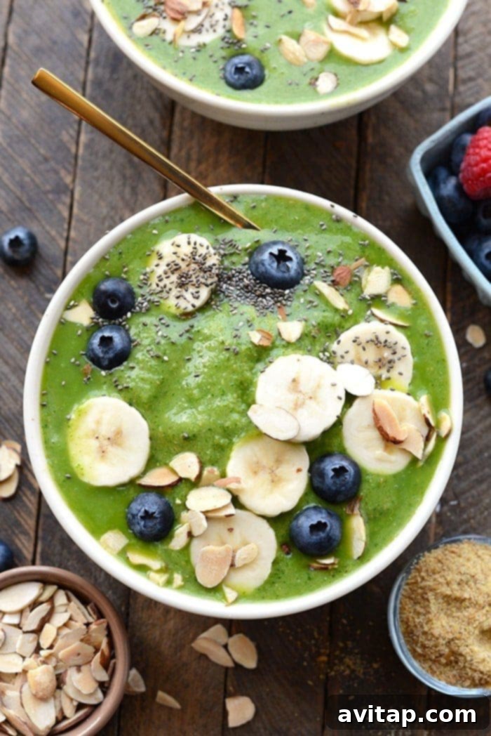Get your daily greens! This delicious Detox Green Smoothie Bowl is packed with spinach, basil, flax, tropical fruit and coconut milk to give it the perfect consistency with no added sugars. Top with your favorite nuts and berries and enjoy this healthy green smoothie recipe today! healthy green smoothie bowl topped with fruit and nuts