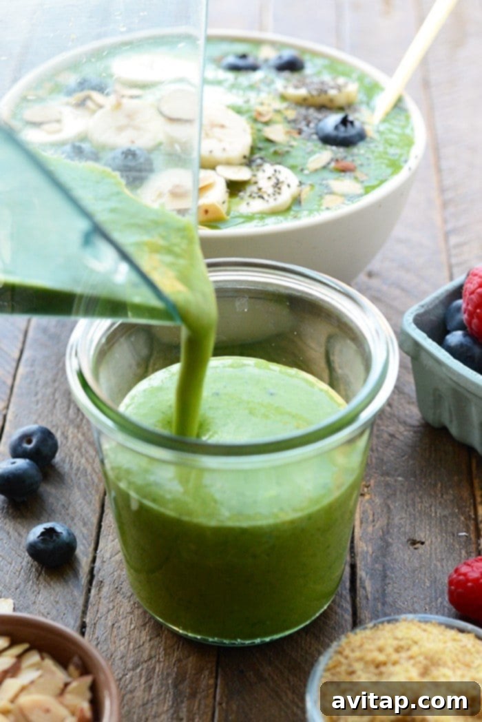 Get your daily greens! This delicious Detox Green Smoothie Bowl is packed with spinach, basil, flax, tropical fruit and coconut milk to give it the perfect consistency with no added sugars. Top with your favorite nuts and berries and enjoy this healthy green smoothie recipe today! healthy green smoothie being poured into a glass