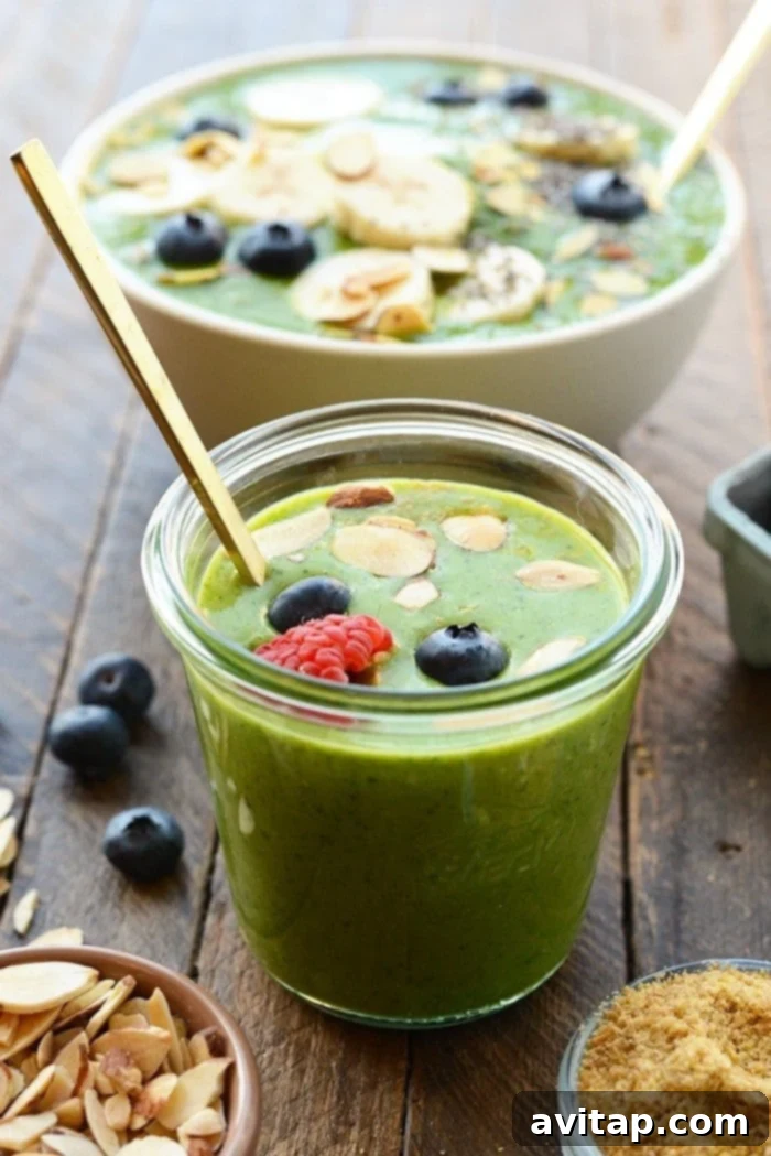 Get your daily greens! This delicious Detox Green Smoothie Bowl is packed with spinach, basil, flax, tropical fruit and coconut milk to give it the perfect consistency with no added sugars. Top with your favorite nuts and berries and enjoy this healthy green smoothie recipe today! healthy green smoothie in a glass topped with berries and nuts