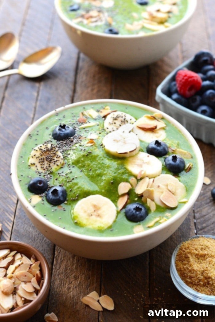 Get your daily greens! This delicious Detox Green Smoothie Bowl is packed with spinach, basil, flax, tropical fruit and coconut milk to give it the perfect consistency with no added sugars. Top with your favorite nuts and berries and enjoy this healthy green smoothie recipe today! healthy green smoothie bowl topped with fruit and nuts and chia seeds