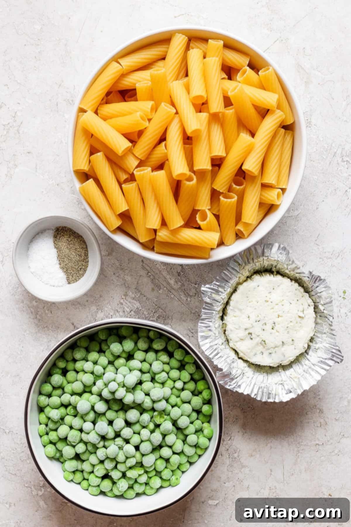 Creamy One-Pot Boursin Pasta 4 A vibrant bowl of pasta, peas, and other ingredients mixed together, showcasing the creamy texture.