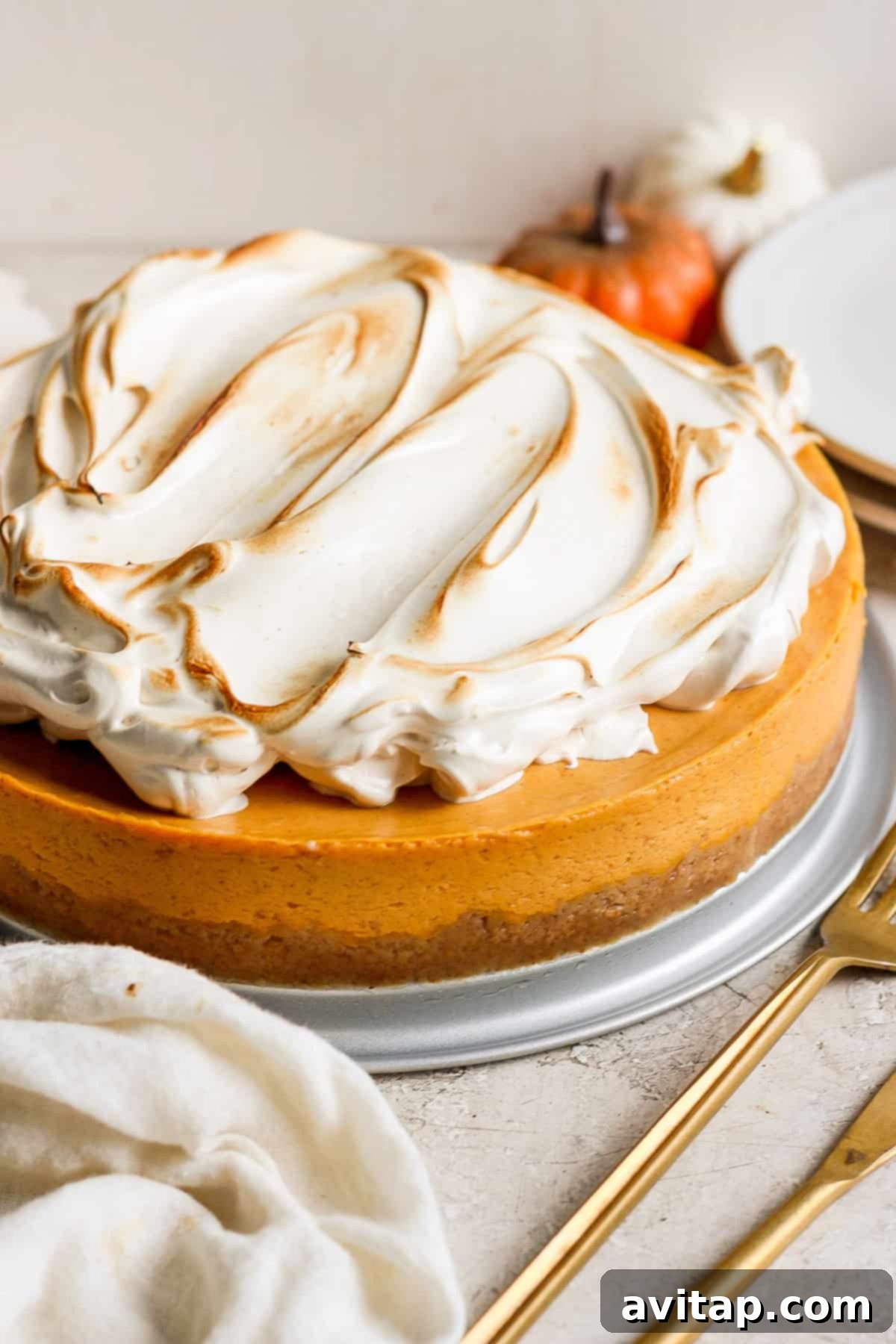A whole high-protein pumpkin cheesecake crowned with a beautiful, toasted brown sugar Swiss meringue.