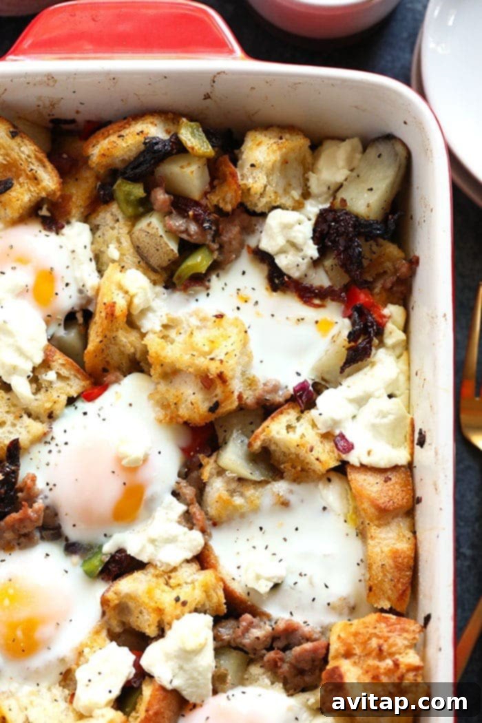 A beautifully baked and finished Spicy Italian Breakfast Casserole, generously topped with perfectly melted goat cheese and garnished with fresh green herbs, presented in a stoneware baking dish, ready to be portioned and served.