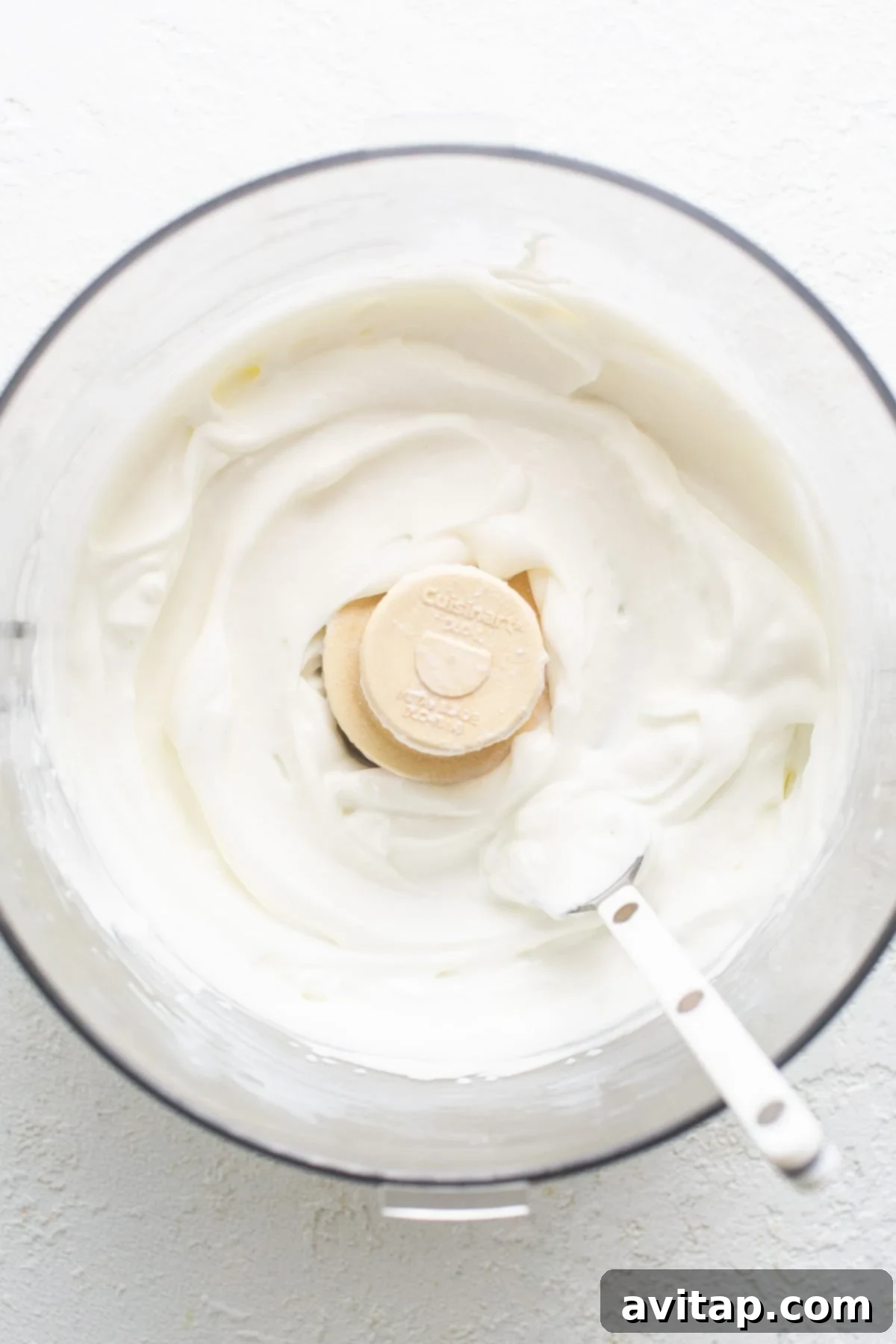 A bowl of whipped cottage cheese ready to be mixed, demonstrating its smooth texture.