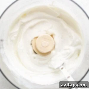 A bowl of whipped cream with a banana slice in it, illustrating the smooth cottage cheese texture.