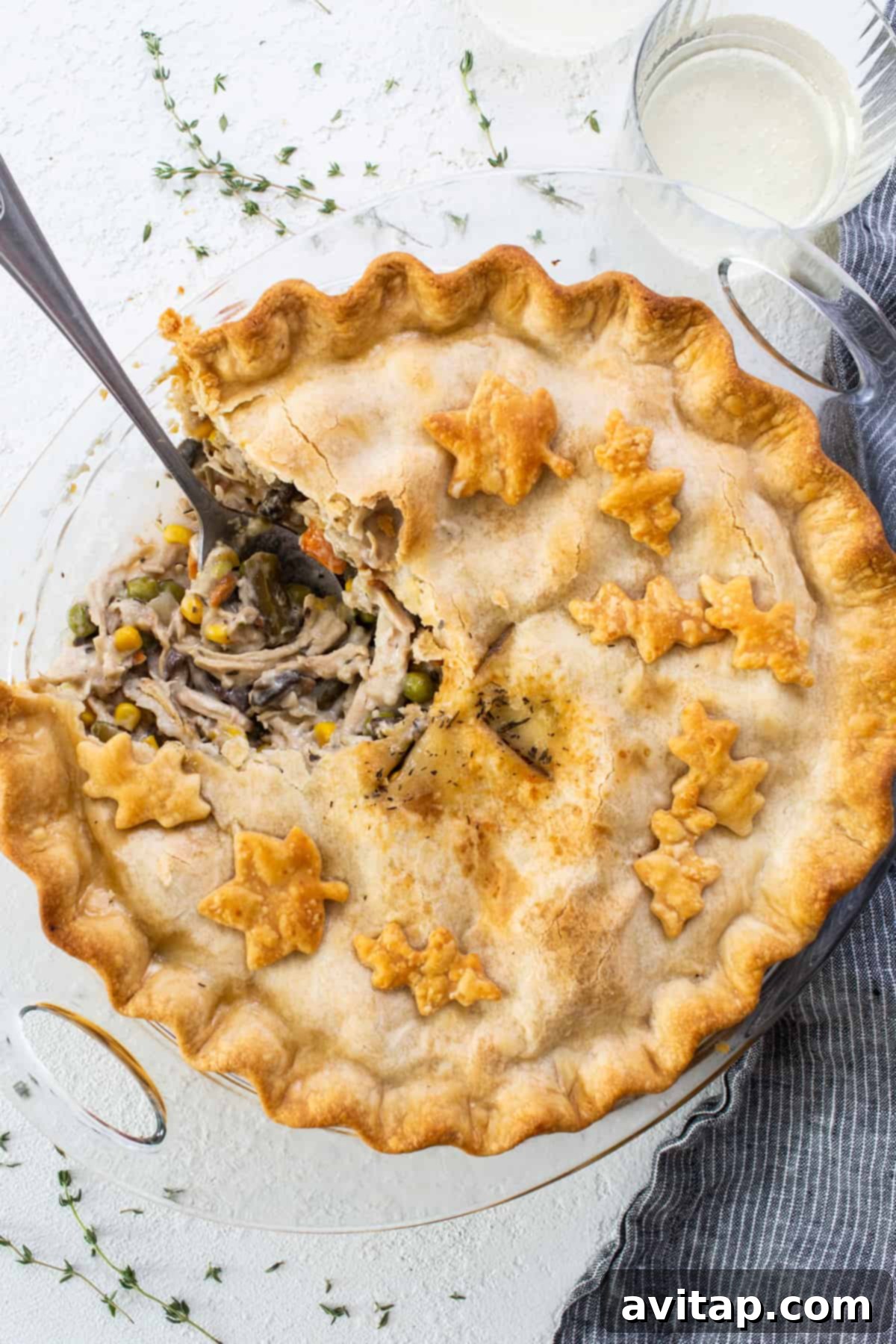 A perfectly baked turkey pot pie with a slice carefully removed, revealing the creamy filling of turkey and vegetables.