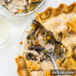 A chicken pot pie on a plate with a slice taken out.