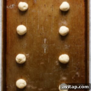 A baking sheet neatly arranged with uniform balls of cookie dough, spaced apart to allow for proper baking and expansion.