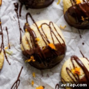 A group of finished chocolate orange ricotta cookies, with their hardened chocolate coating and vibrant orange zest, ready to be enjoyed.