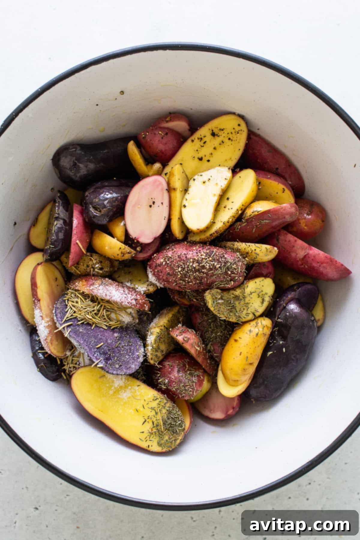 seasoning potatoes in bowl.