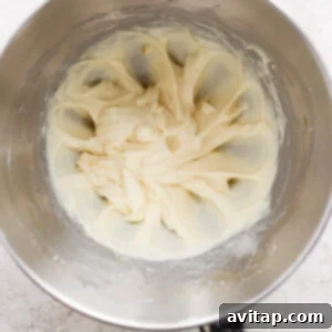A bowl of whipped cream in a metal bowl.