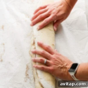 A woman's hands slicing a loaf of bread.