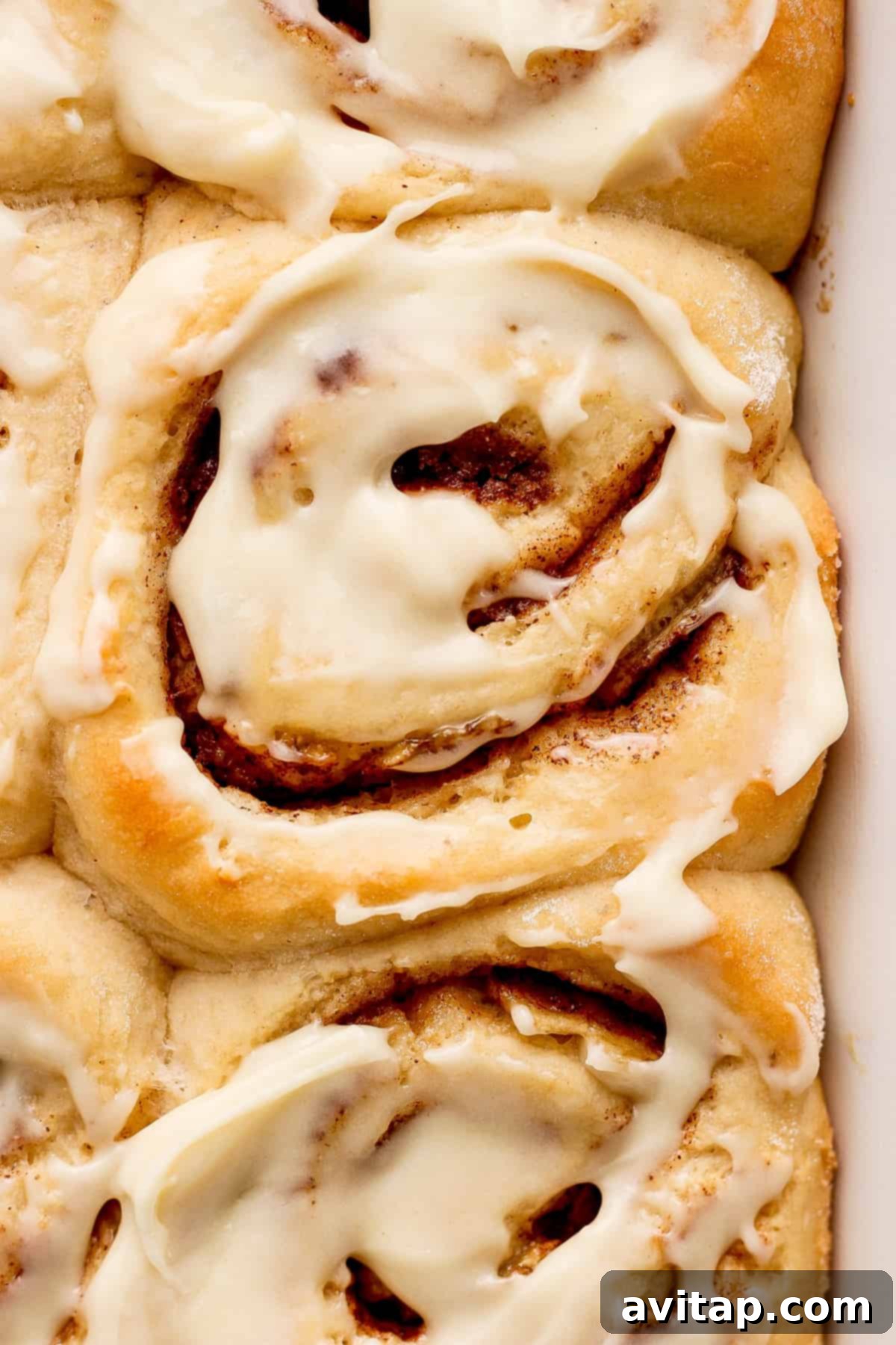 Cinnamon rolls in a baking dish with icing.