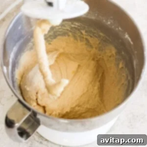 A bowl of dough being mixed in a mixer.