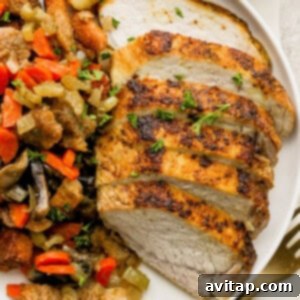 A plate with expertly sliced pork tenderloin and a hearty serving of mushroom stuffing, ready to be enjoyed.