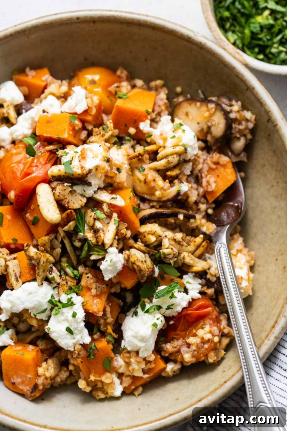 A bowl filled with quinoa, squash and feta.