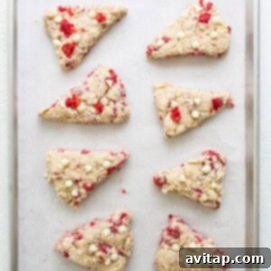 Chilled cranberry almond scones on a baking sheet, ready to go into the oven.