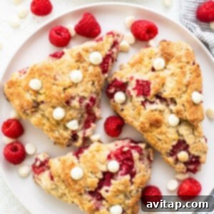 A white plate with a delicious white chocolate raspberry scone, ready to be served.
