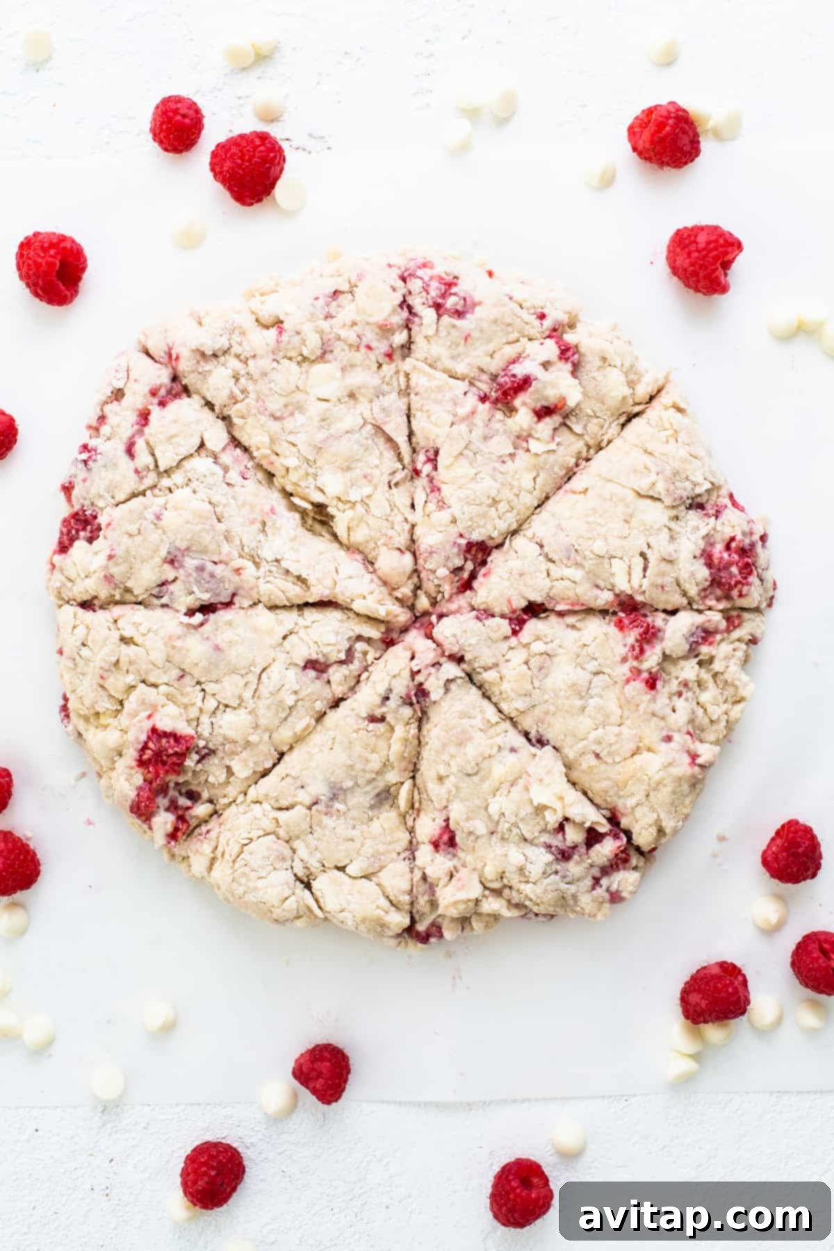Close-up of baked raspberries and white chocolate scones, showcasing their golden-brown tops and rich texture.