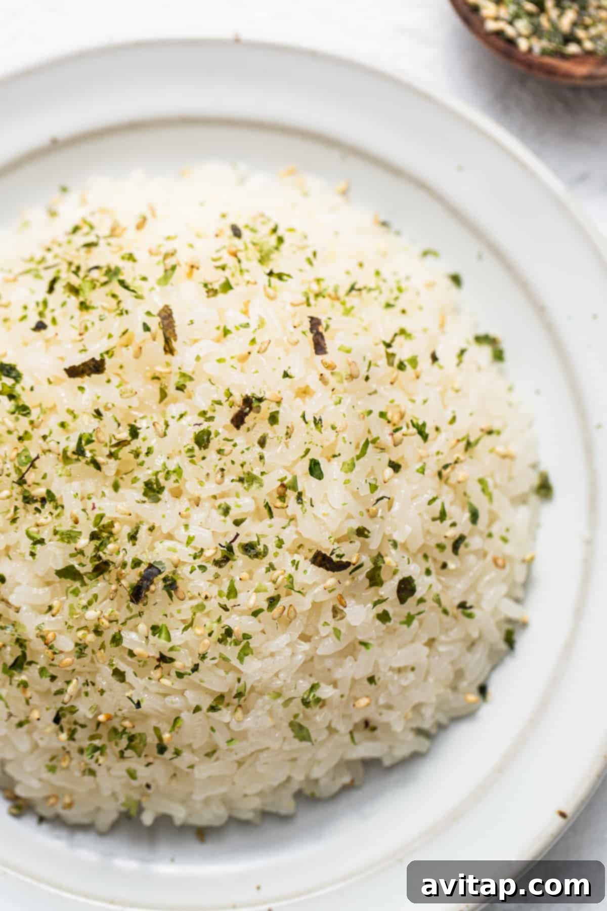 Sticky Rice Magic in the Instant Pot 2 White rice on a plate with herbs and spices.
