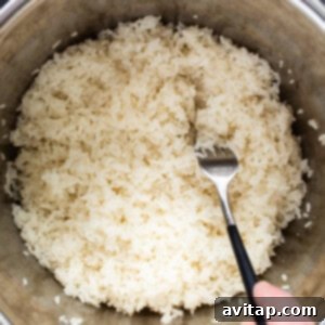 Sticky Rice Magic in the Instant Pot 10 A person pouring rice into an instant pot.