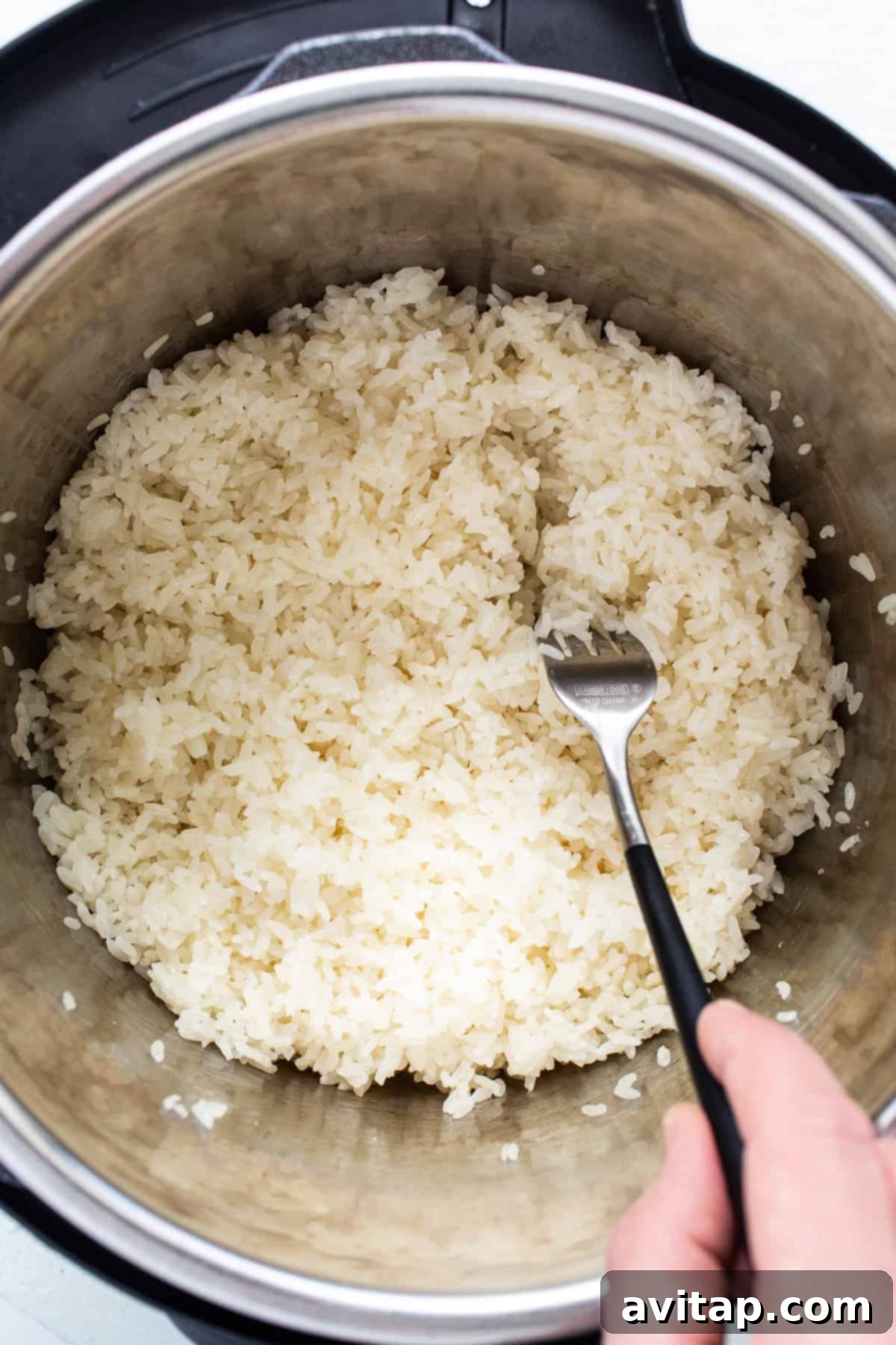 Sticky Rice Magic in the Instant Pot 4 A person pouring rice into an instant pot.