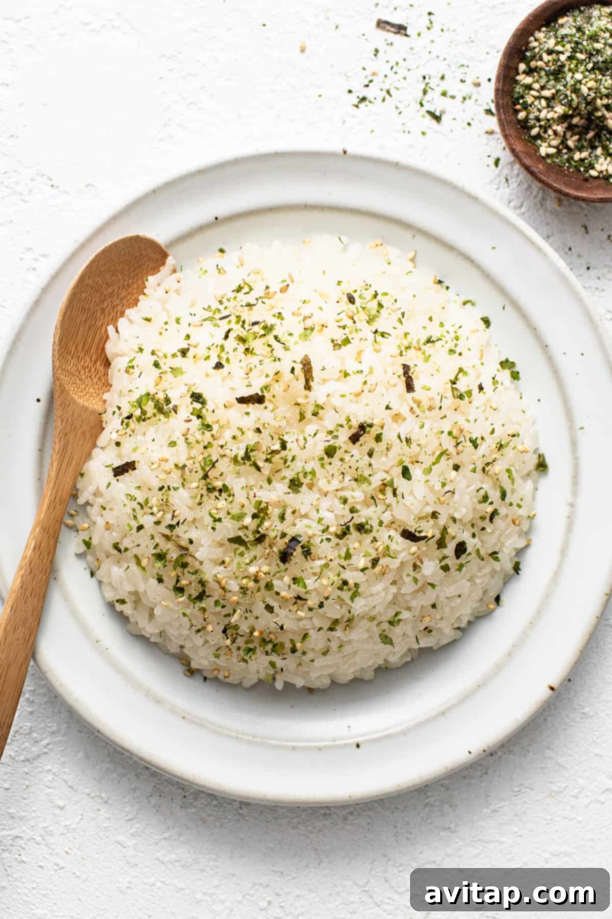 Sticky Rice Magic in the Instant Pot 6 White rice on a white plate with a wooden spoon.