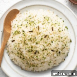 Sticky Rice Magic in the Instant Pot 7 Japanese rice on a white plate with a wooden spoon.