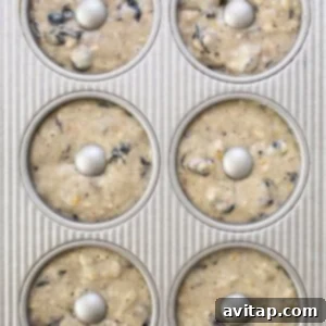 A muffin tin filled with batter, showing how to fill donut wells.