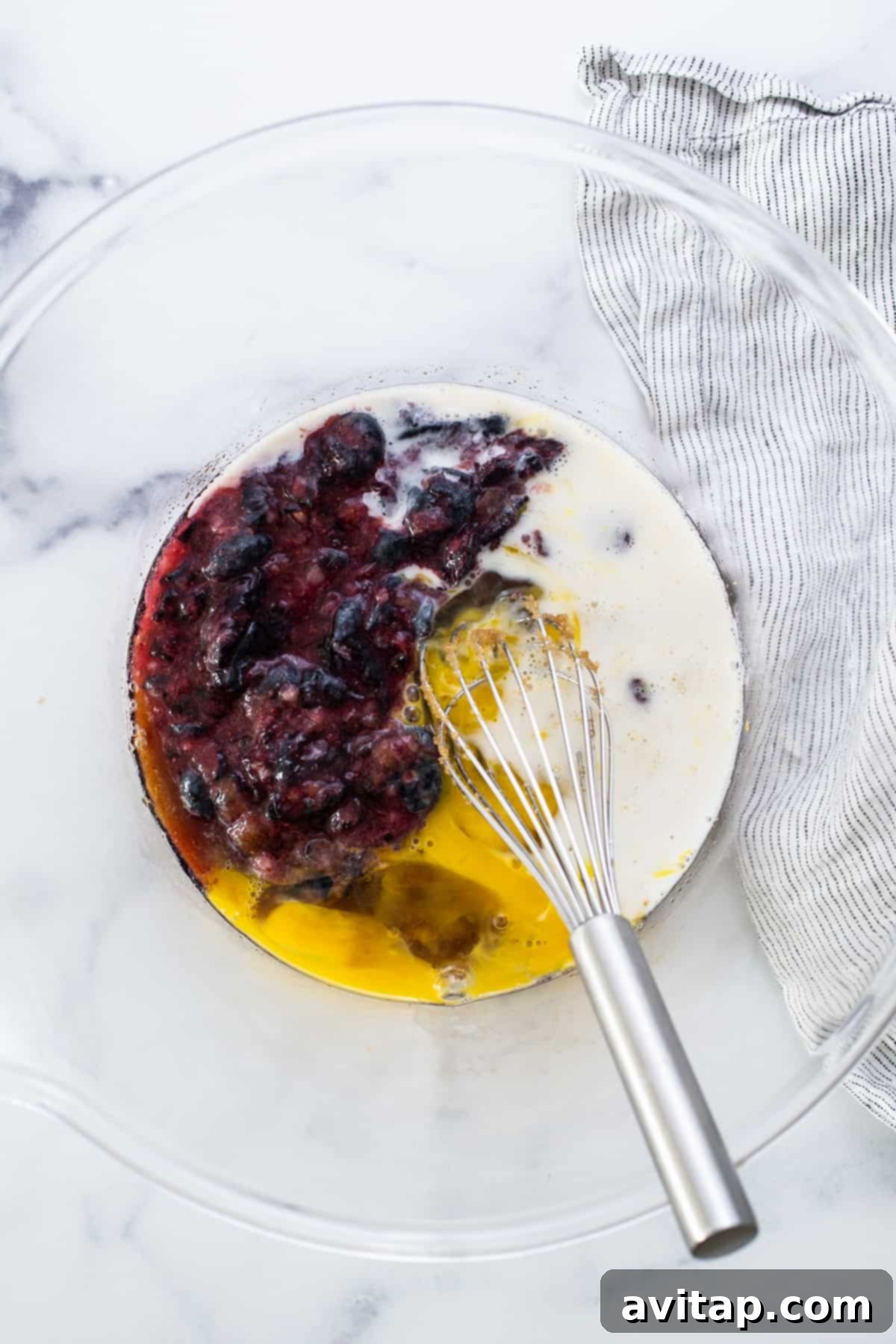 A rustic bowl filled with fresh blueberries and eggs, key ingredients for a delicious donut recipe.