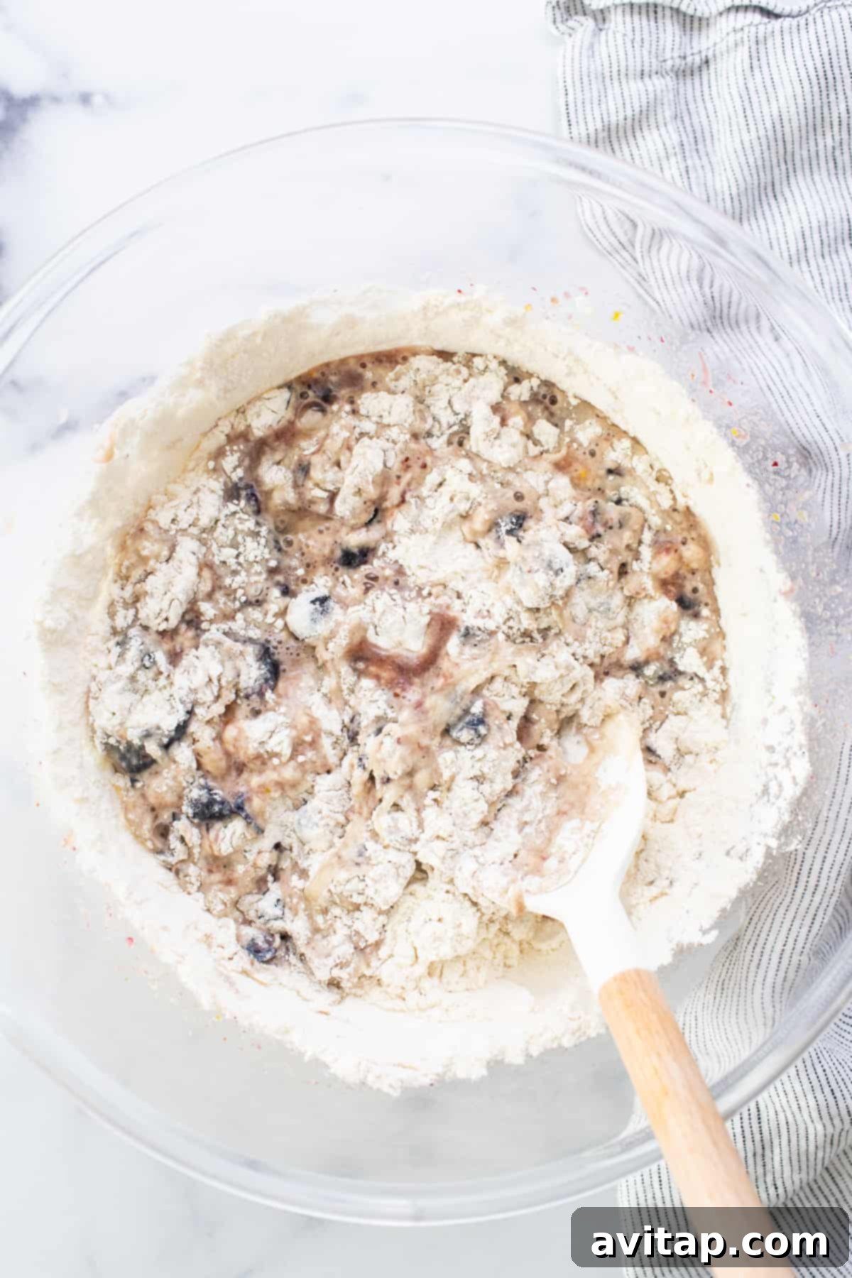 A bowl of oats with a wooden spoon, illustrating the process of combining ingredients.