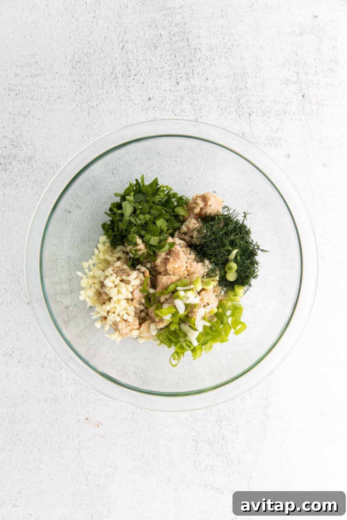 A bowl overflowing with all the vibrant ingredients for the salmon salad, perfectly mixed and ready to be scooped into avocados.