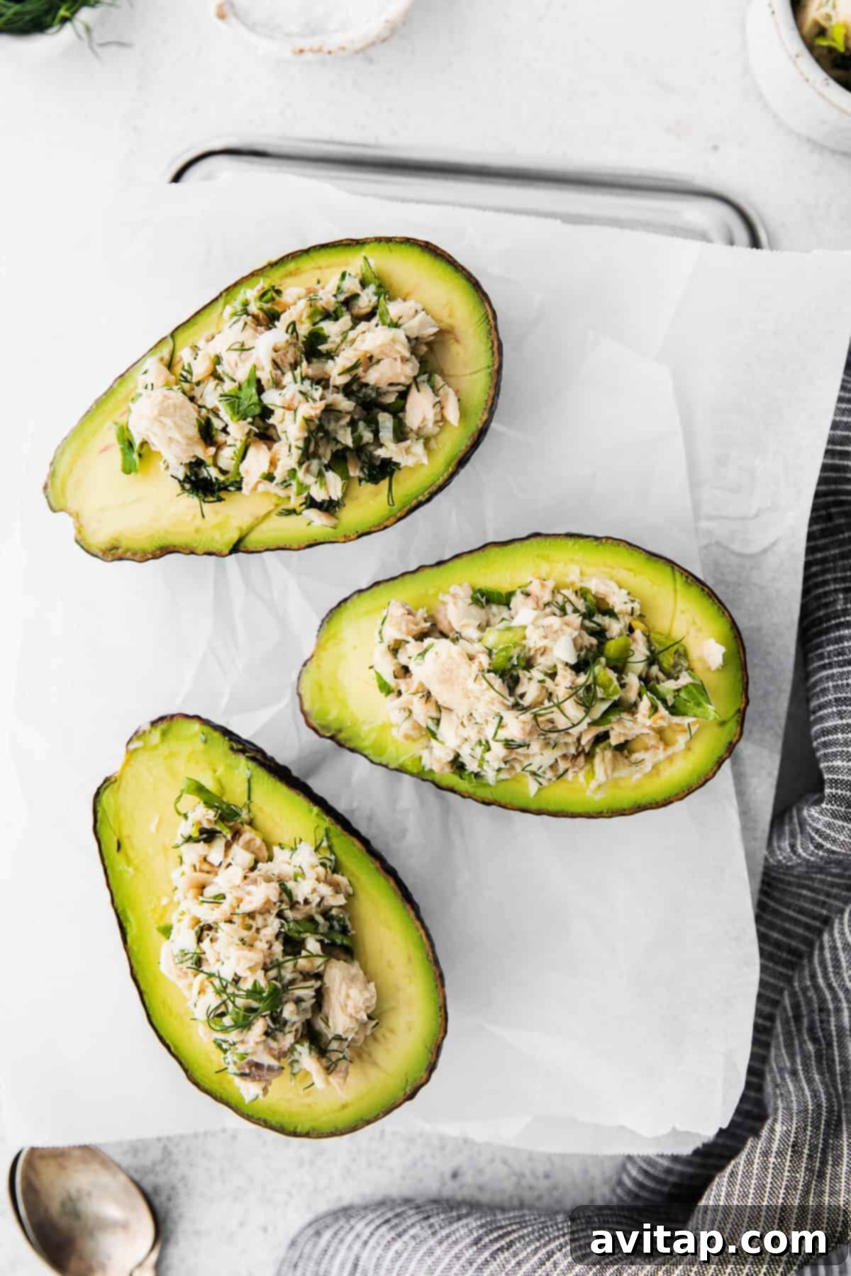 Exquisitely prepared avocado boats, generously stuffed with a fresh and vibrant salmon salad, presented beautifully and ready for enjoyment.