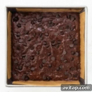 A brownie in a baking pan with chocolate chips.