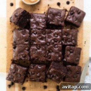 Chocolate brownies on a cutting board with peanut butter.