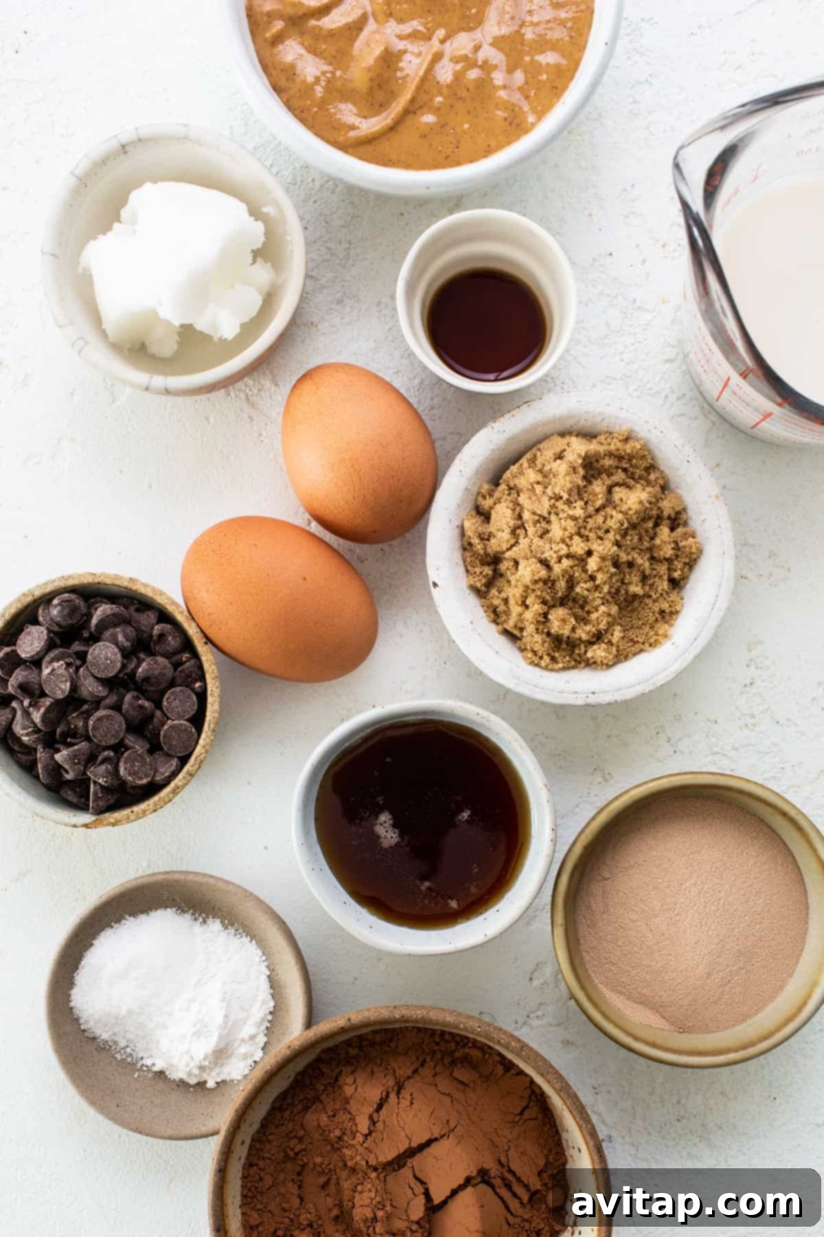 Peanut Butter Protein Power Brownies 3 The ingredients for a chocolate cake are shown in bowls on a white background.