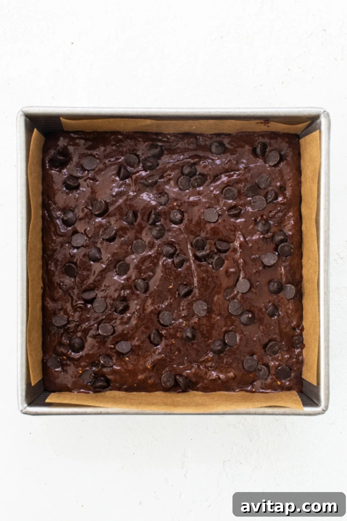 Peanut Butter Protein Power Brownies 5 A brownie in a baking pan with chocolate chips.