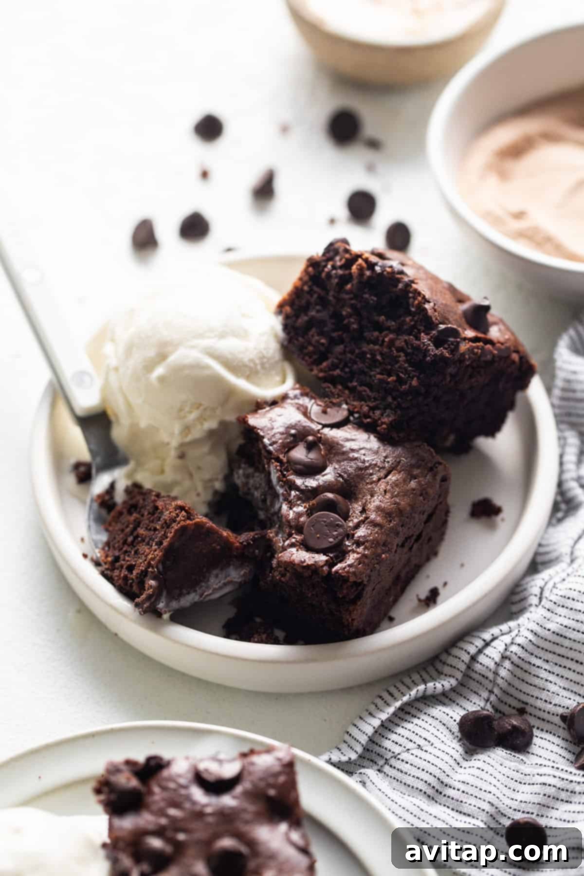Peanut Butter Protein Power Brownies 6 A plate of chocolate brownies with ice cream and a scoop of ice cream.