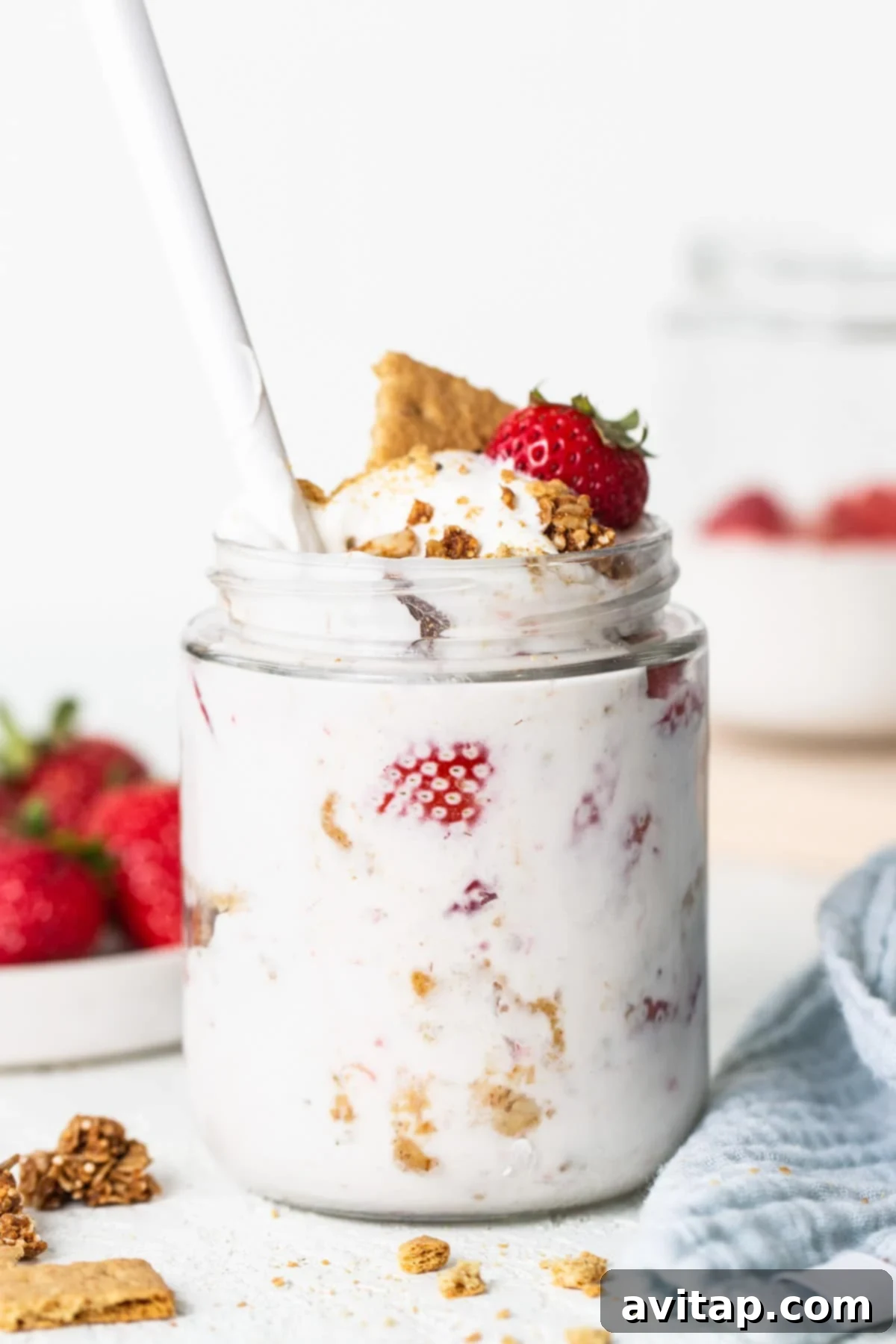 A jar of yogurt with strawberries and granola.