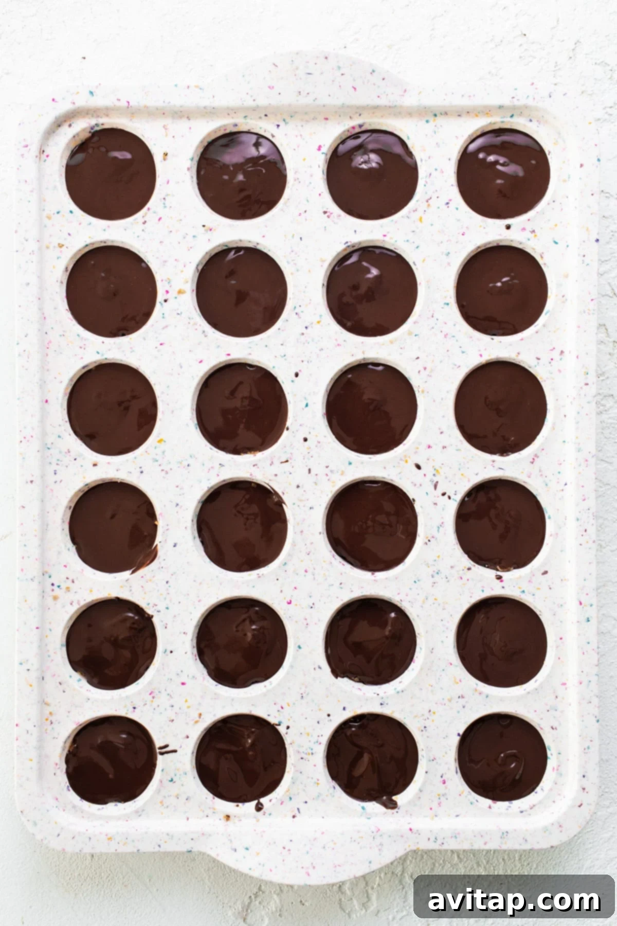 A tray of chocolate covered donuts, reflecting the aesthetic of the final chocolate-topped protein cups.