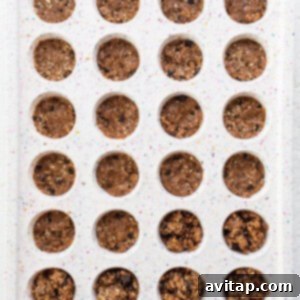 A tray filled with neatly scooped chocolate chip cookie dough portions, ready for shaping into cups, showing the uniformity of the base layer.