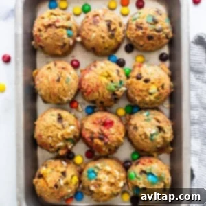Protein Packed Monster Cookie Dough 11 A baking sheet filled with an arrangement of baked monster cookies, featuring vibrant M&M's and chocolate chips.